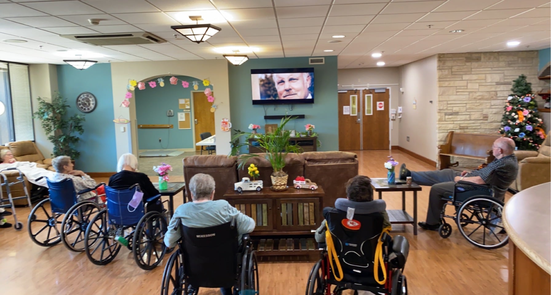 long term care residents in wheelchairs watching tv